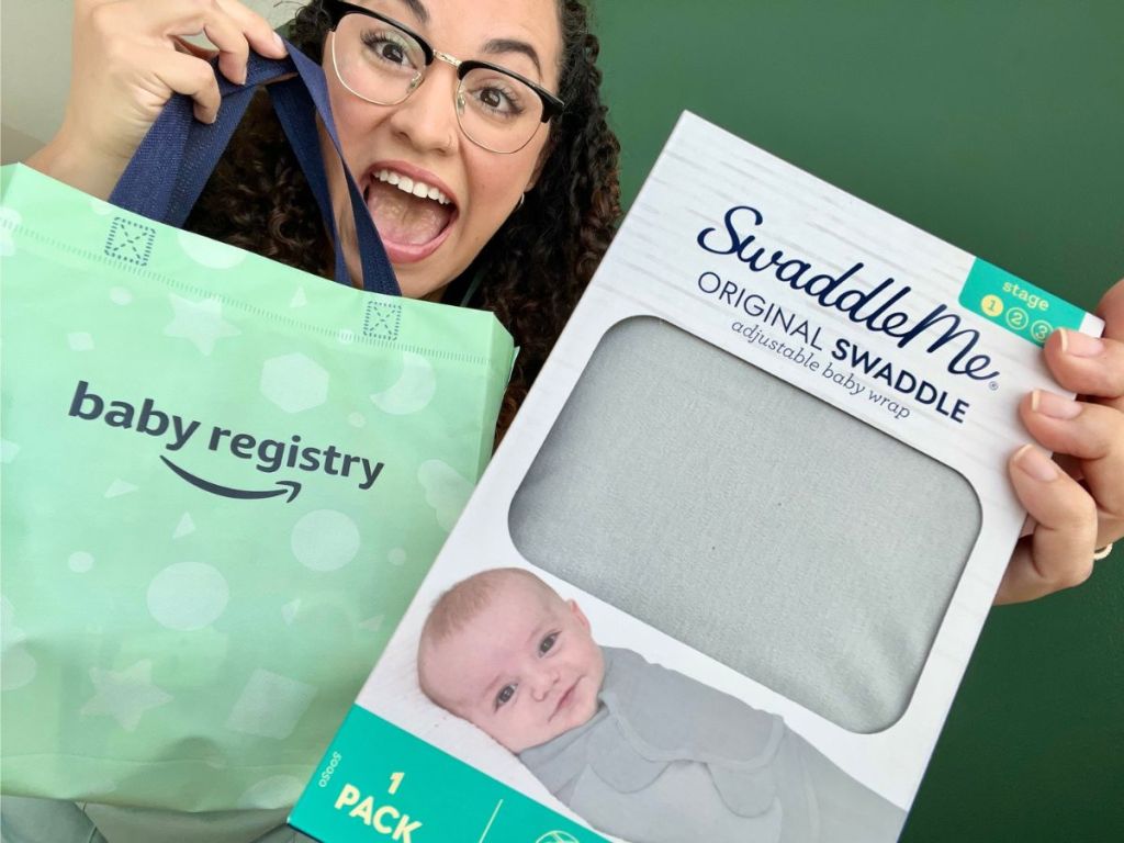 Woman holding an Amazon baby registry bag and a swaddleme swaddle.