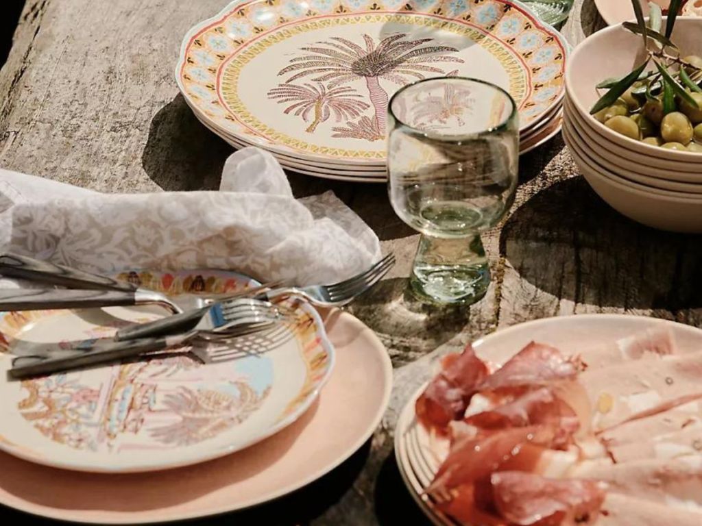 Plates, napkins, and glasses with food on a table