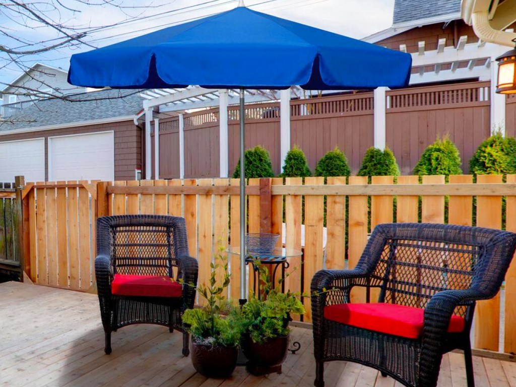 Blauer Sonnenschirm über zwei Terrassenstühlen