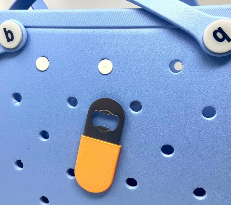 orange bottle opener sticking to outside of blue bogg bag