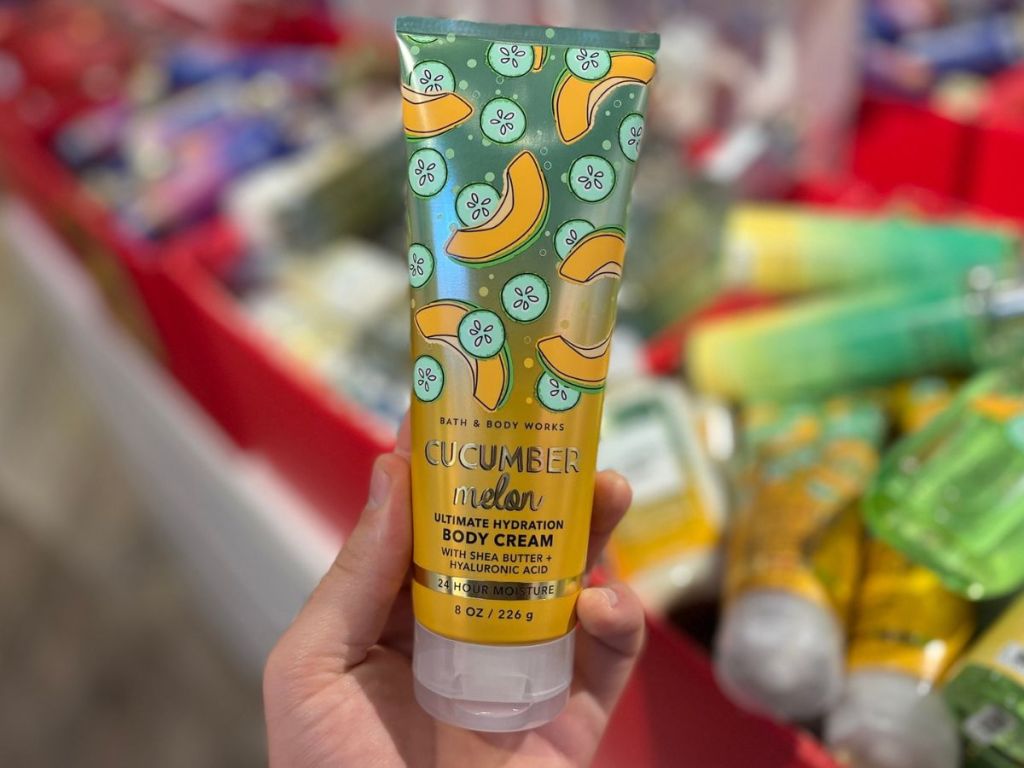 Hand holding up a tube of Cucumber Melon body lotion
