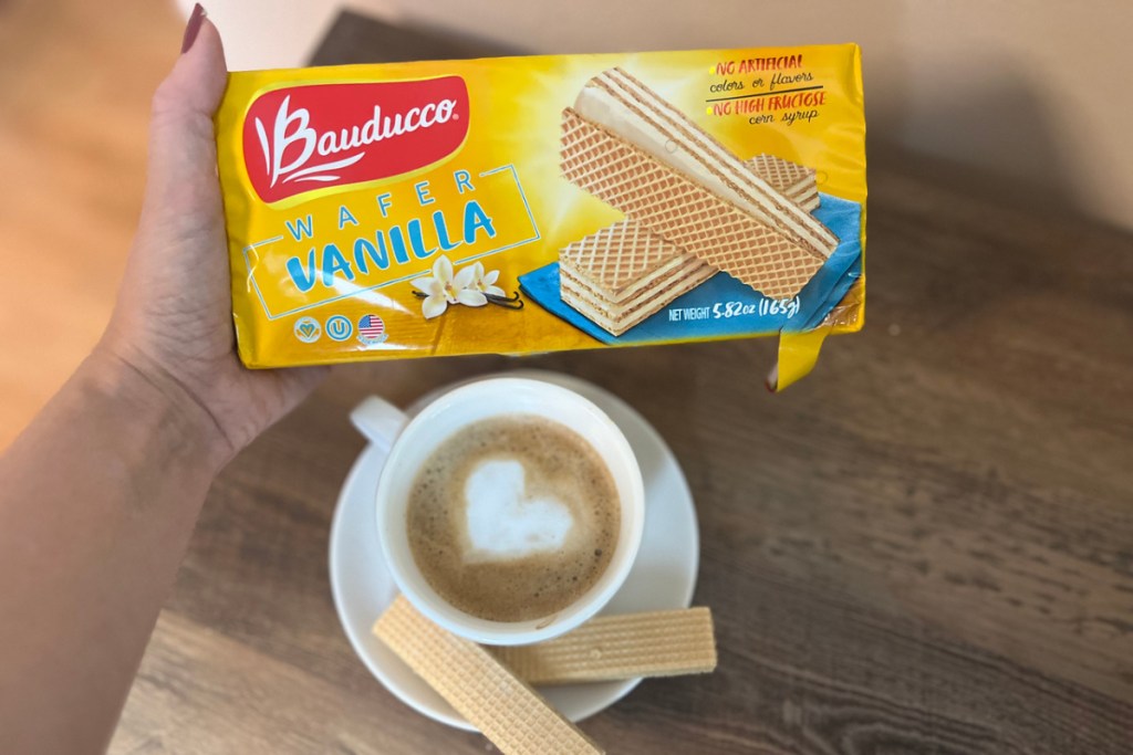 woman holding a Bauducco Vanilla Wafers package above coffee