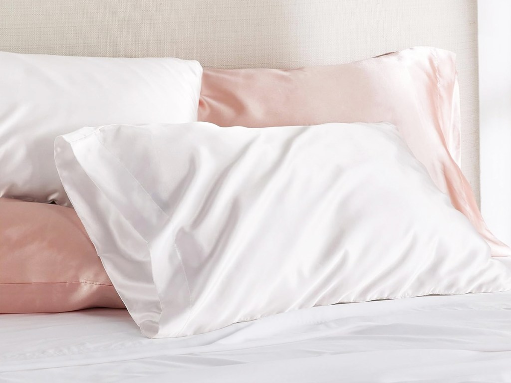 white and pink satin pillowcases on bed