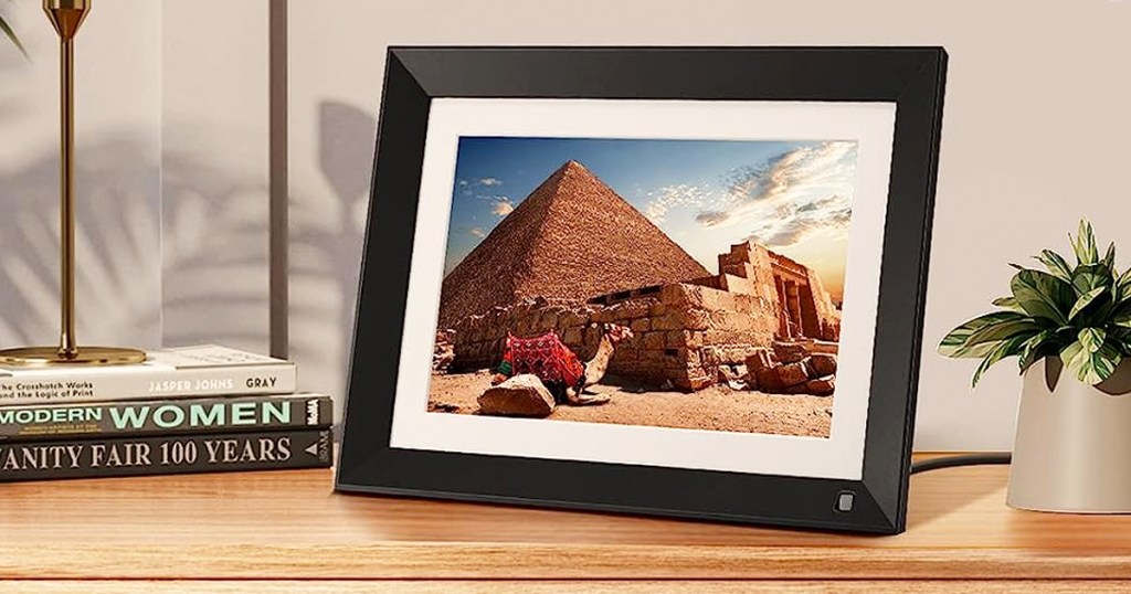 digital picture frame on table display photo of a camel in front of the pyramids