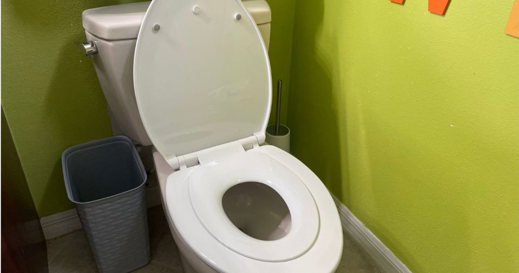 toilet with toddler seat attached in bathroom