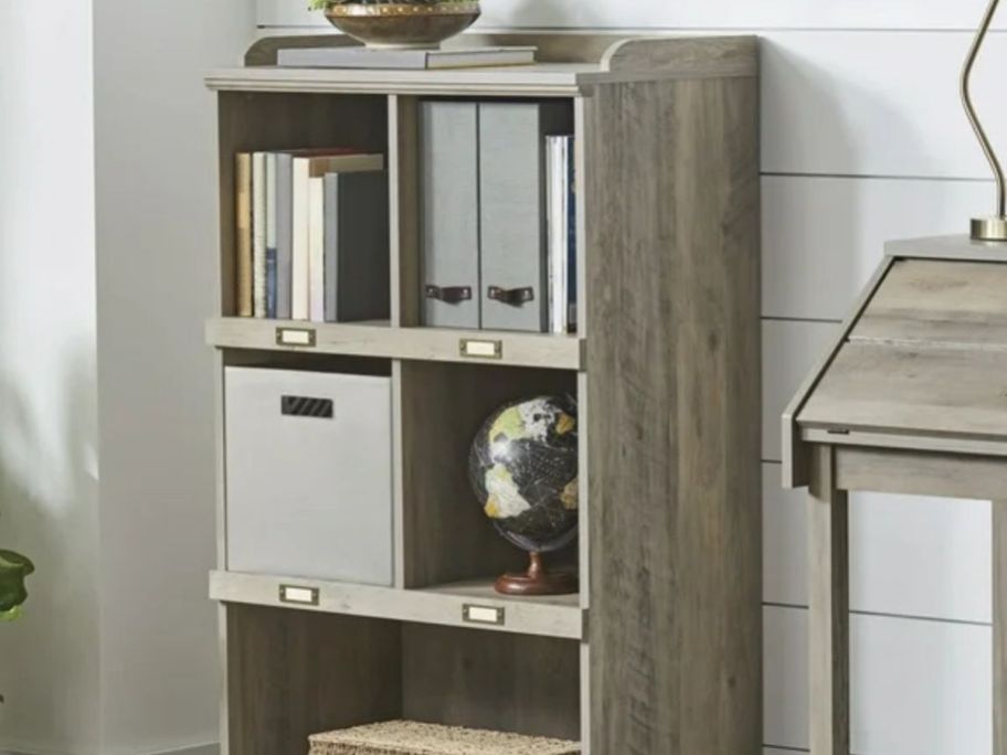 A dark cube storage organizer with gray canvas baskets in an entryway