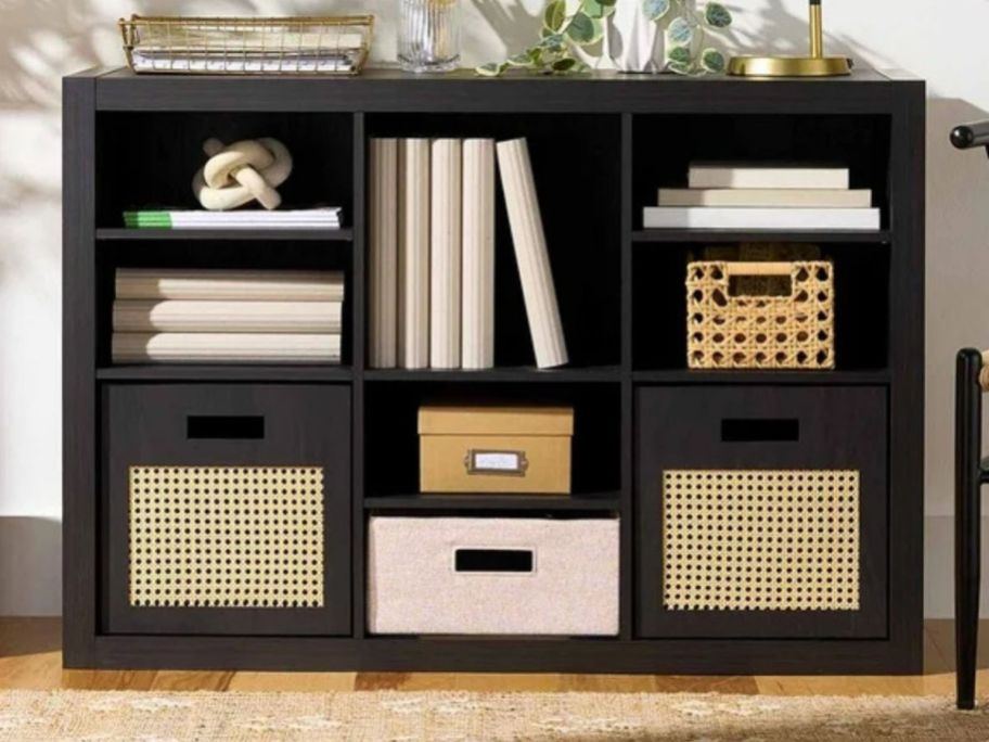 A dark cube storage organizer with blue canvas baskets in it