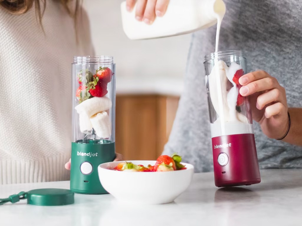 pouring milk into a smoothie in a blendjet blender