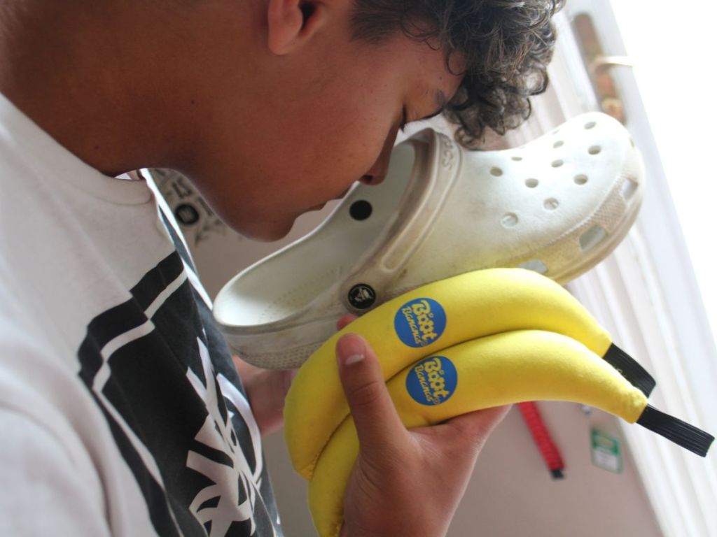 teen smelling his Croc swhoe while holding Boot bananas