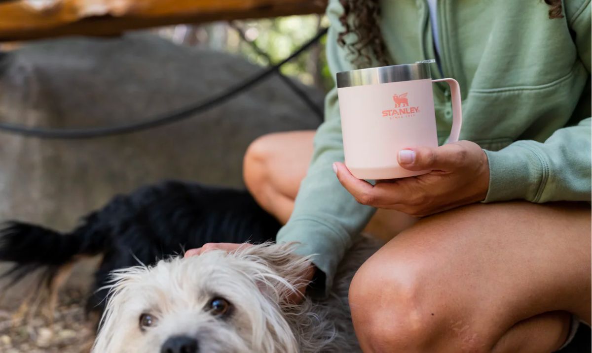 a woman petting a dog and drinking out of a CLASSIC LEGENDARY CAMP MUG 12 OZ