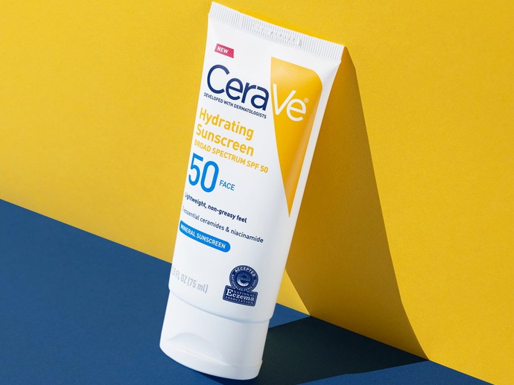 bottle of cerave face sunscreen leaning against yellow wall