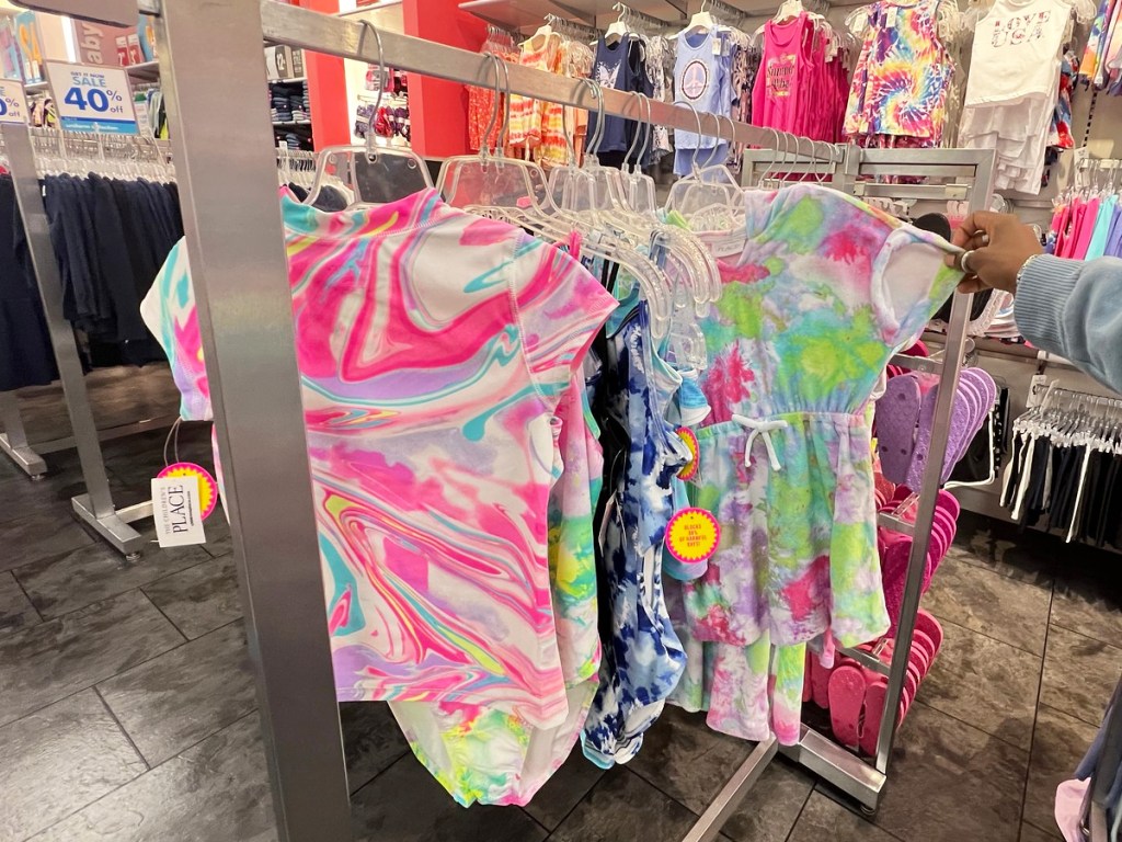 girls bathing suits hanging on store display rack