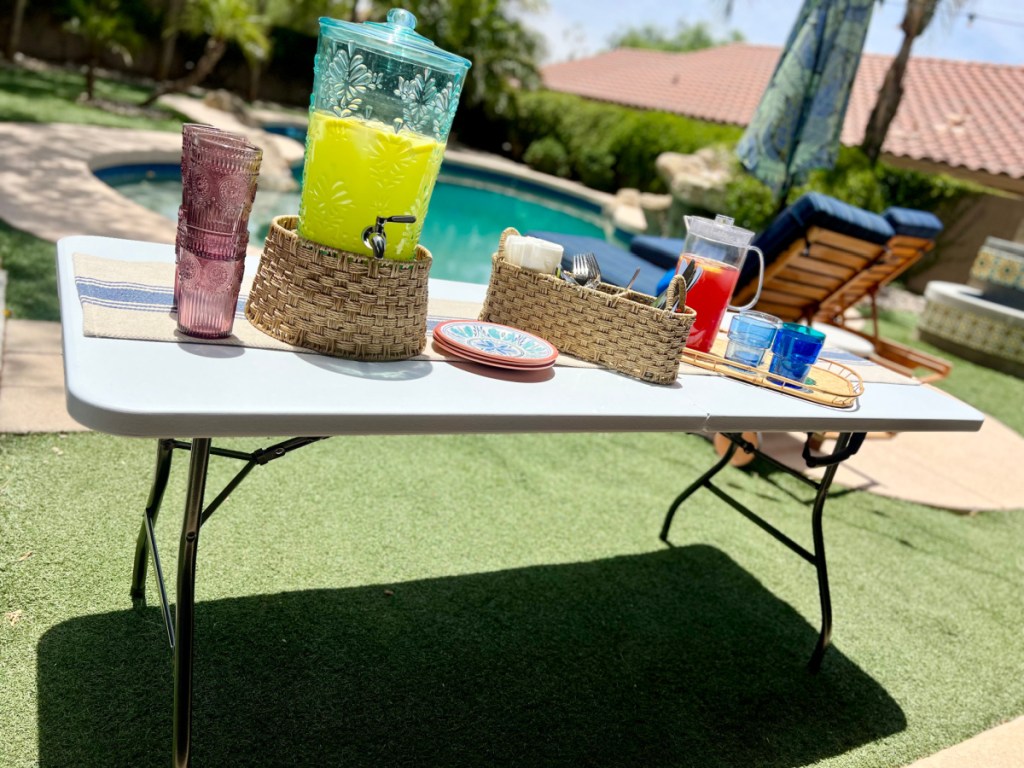 A Cosco 6 foot folding table set up at an outdoors backyard party