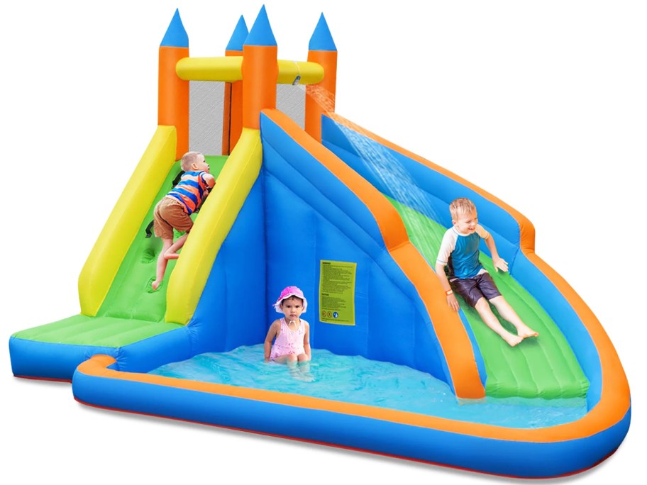 three kids playing on giant inflatable water slide