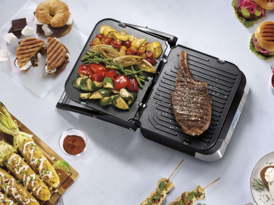 Cuisinart Contact Griddler with Smoke-Less Mode displayed with food on it and around