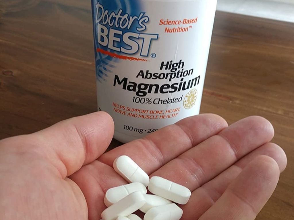 hand full of Doscor's Best magnesium Tablets