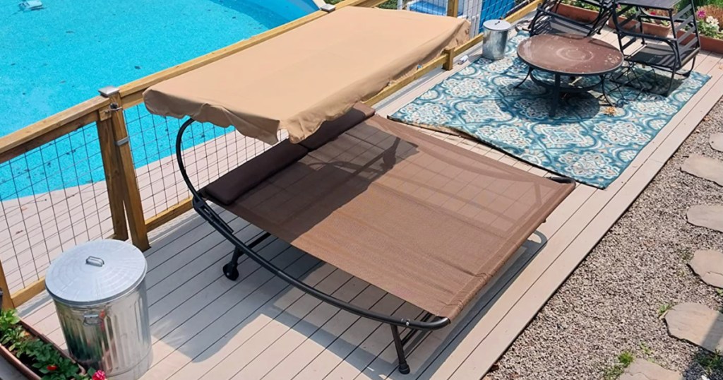 Brown double hammock bed set up outside next to pool