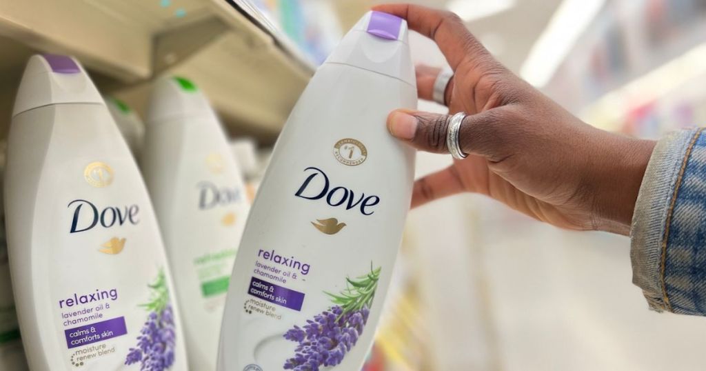 hand tipping a Dove relaxing lavendar body wash off the store shelf