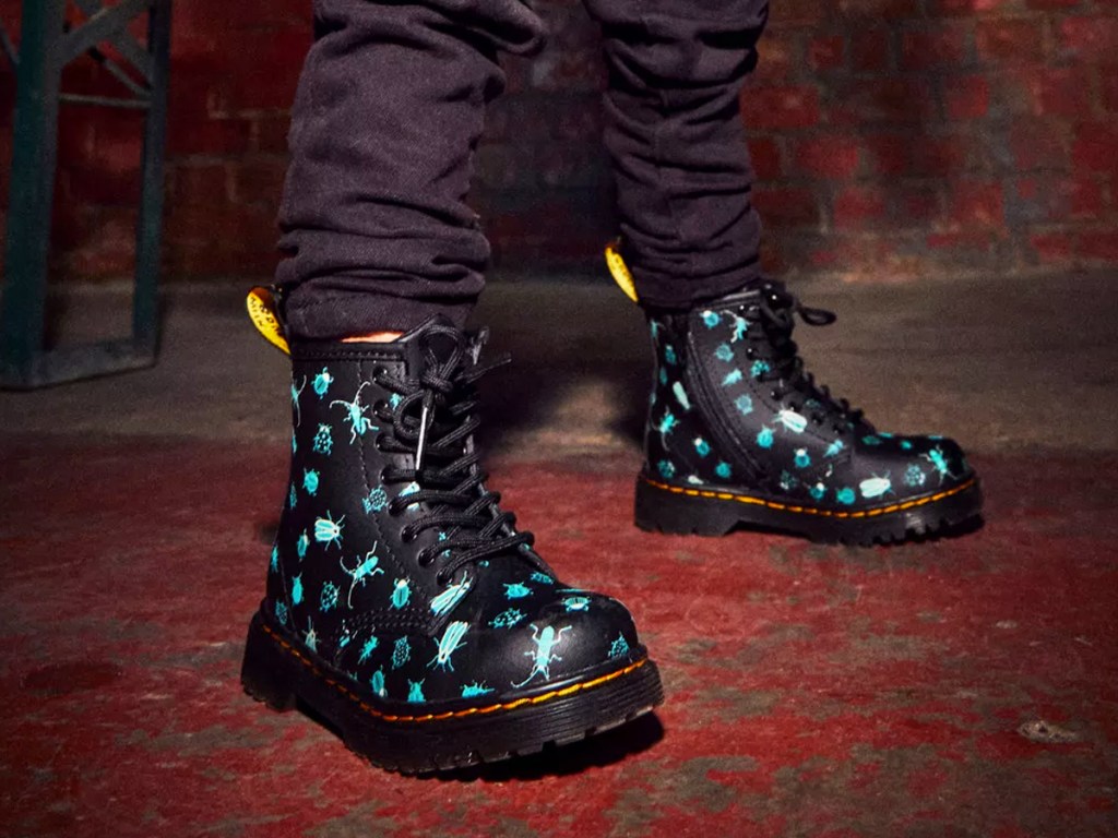 boy wearing black boots with blue bug print