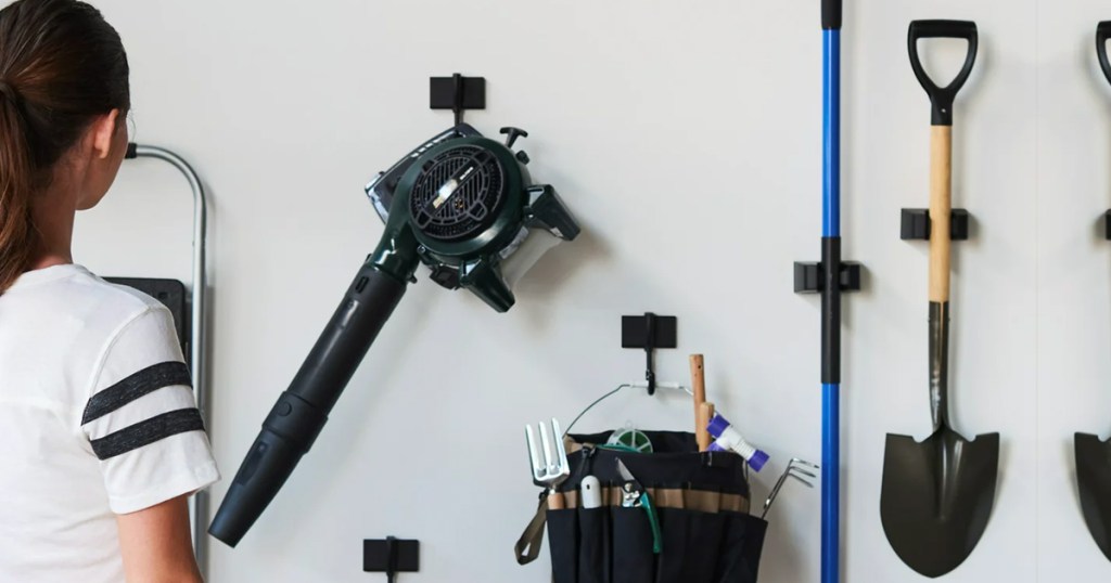 woman looking at tools hanging on garage wall