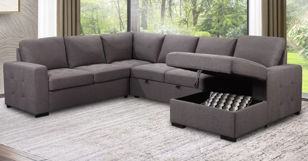 grey sectional in living room with lounge lifted up to show storage space