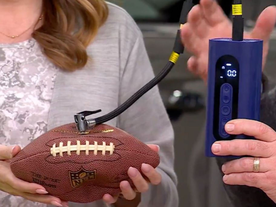 woman and a man using an energizer air compressor to blow up a football