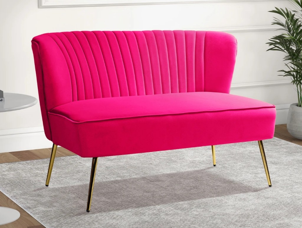 Bright pink couch with gold legs