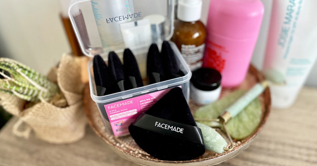 black triangle powder puffs on tray with other beauty products
