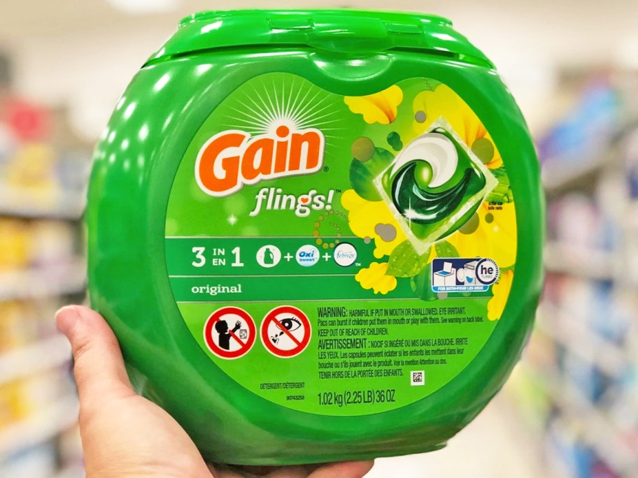 hand holding a green container of gain flings