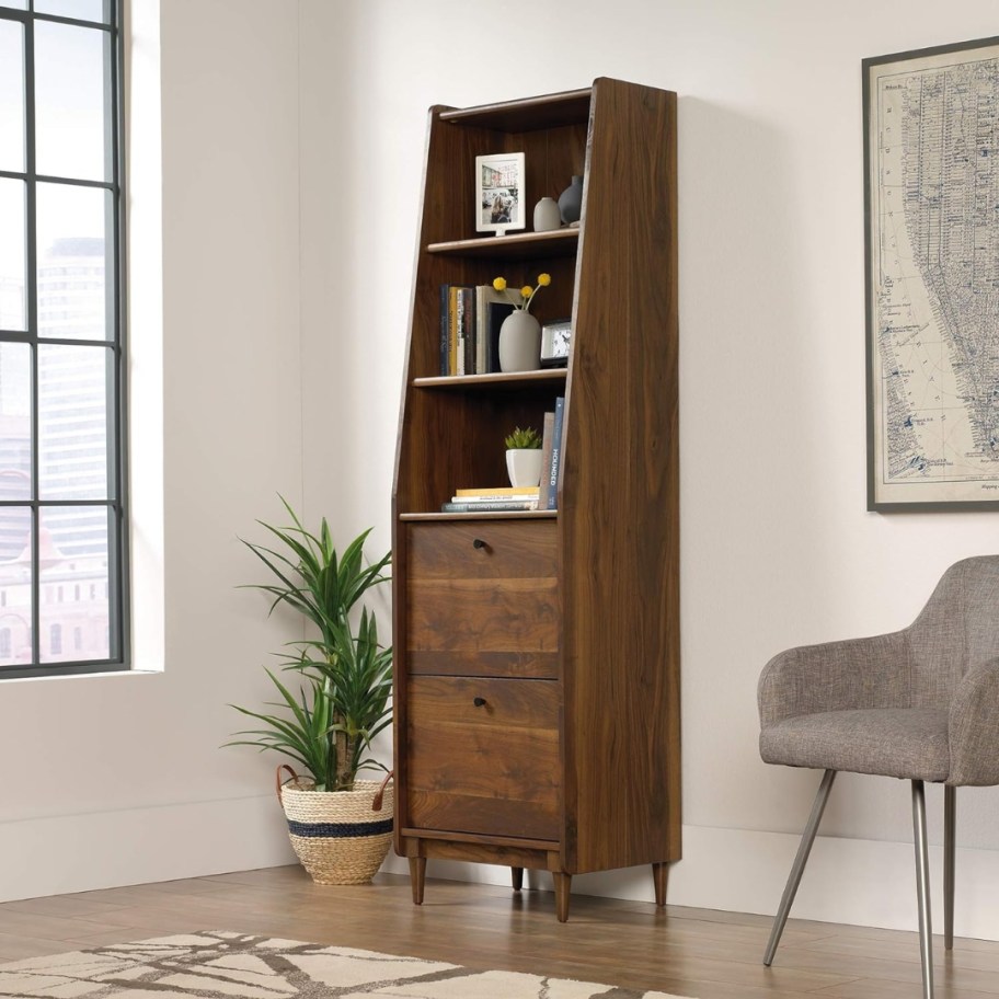 mid century modern style dark wood bookcase and cabinet sitting in a room