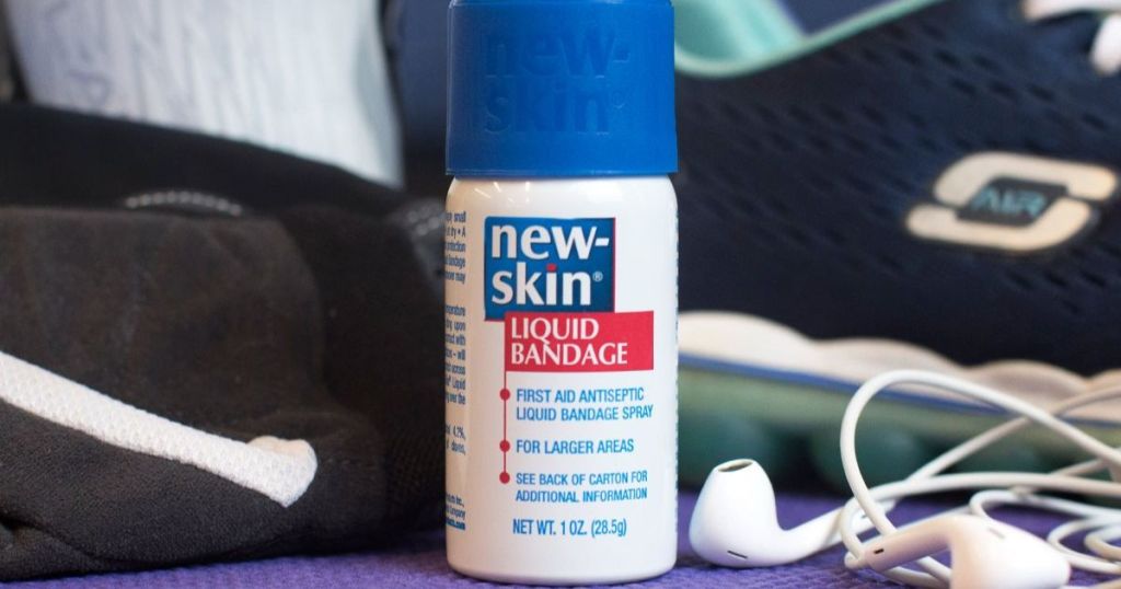 New-Skin Liquid Bandage bottle shown beside of gym bag and earbuds