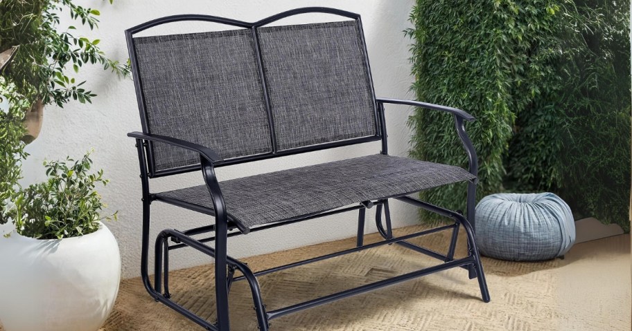 black and grey patio glider chair on a back patio