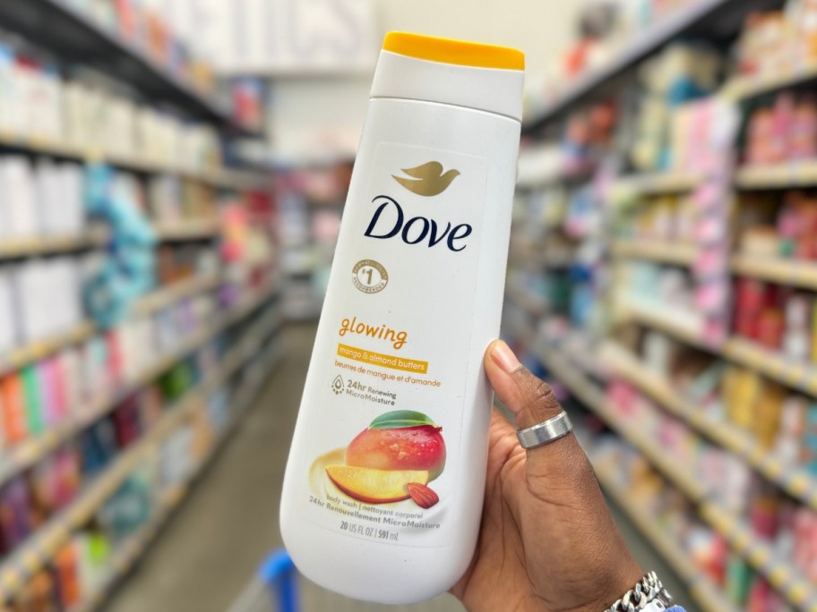 hand holding a bottle of Dove Glowing Mango and Almond Body Wash 