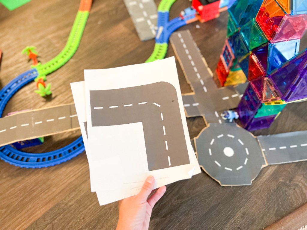 hand holding printable road paper over toys