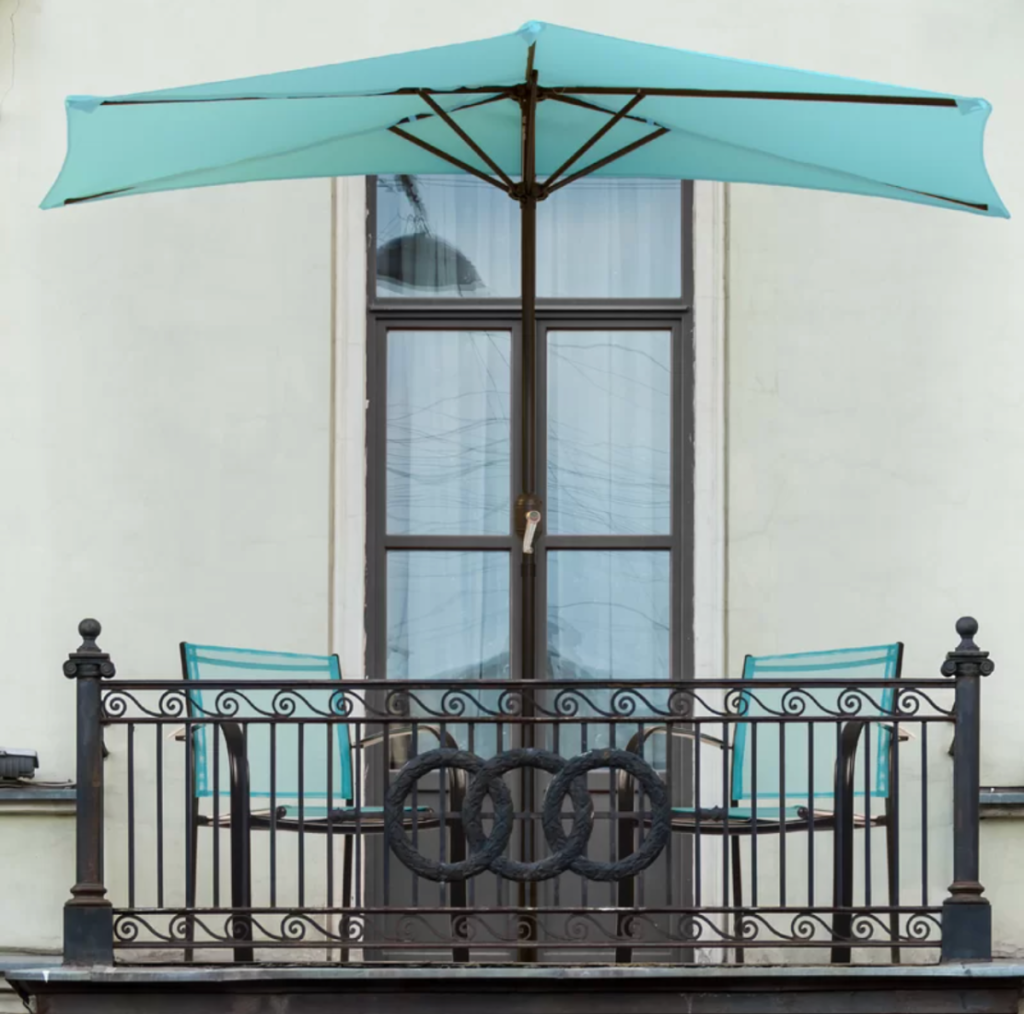 A half patio umbrella set up on a balcony