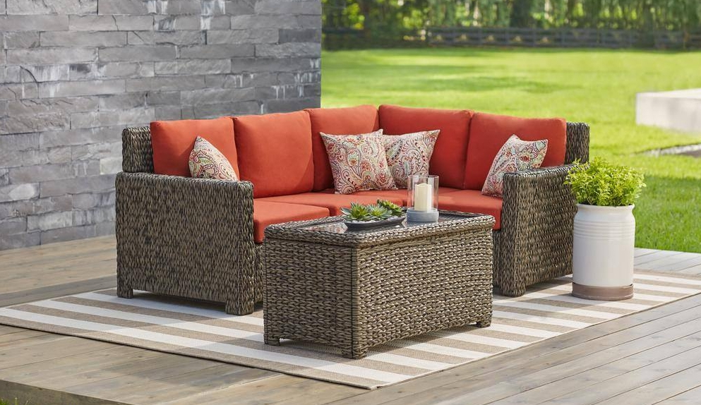 Sectional patio set with red cushions and a planter next to it