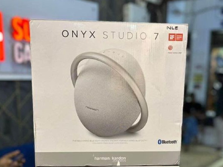 Harmon Kardon Onyx Studio 7 Portable Bluetooth Speaker in gray displayed at a store