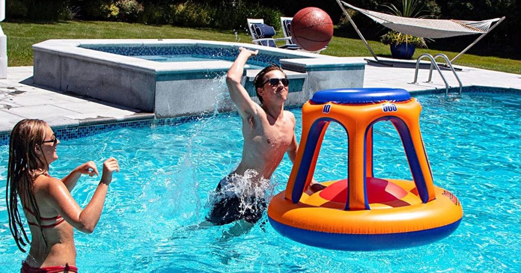 Woman and Man in a pool playing basketball with the SWIMLINE Inflatable Pool Basketball Hoop Floating Or Poolside Game