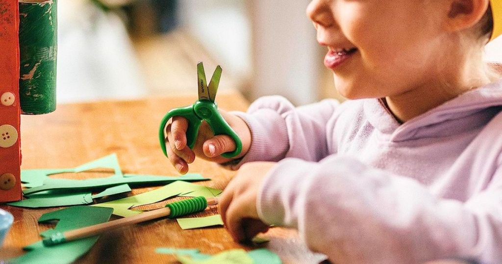 Child using Fiskars Blunt Tip Scissors with construction paper
