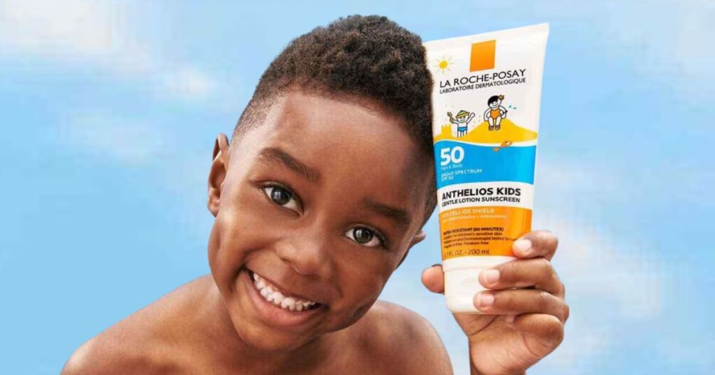 Little boy holding a bottle of La Roche-Posay Kid's Sunscreen with SPF 50