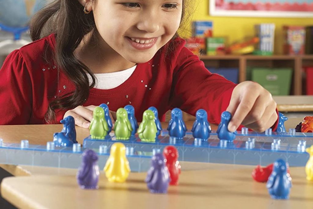 Little girl playing with a Learning Resources Penguins On Ice Math Activity Set