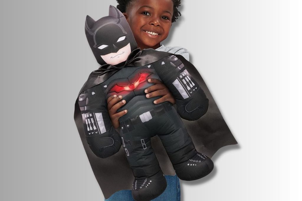 Little boy holding BATMAN The Bashin’ Battler Talking 18-Inch Plush Toy with Light-up Chest and Action Phrases,