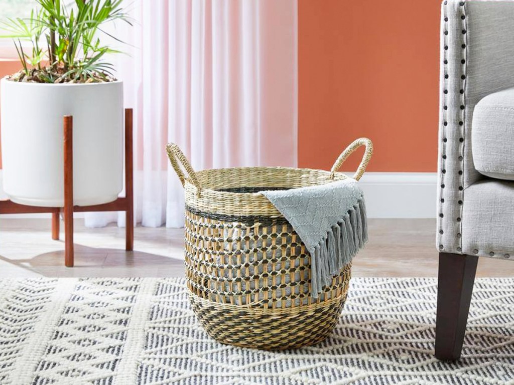 large round basket on floor with throw blanket inside of it