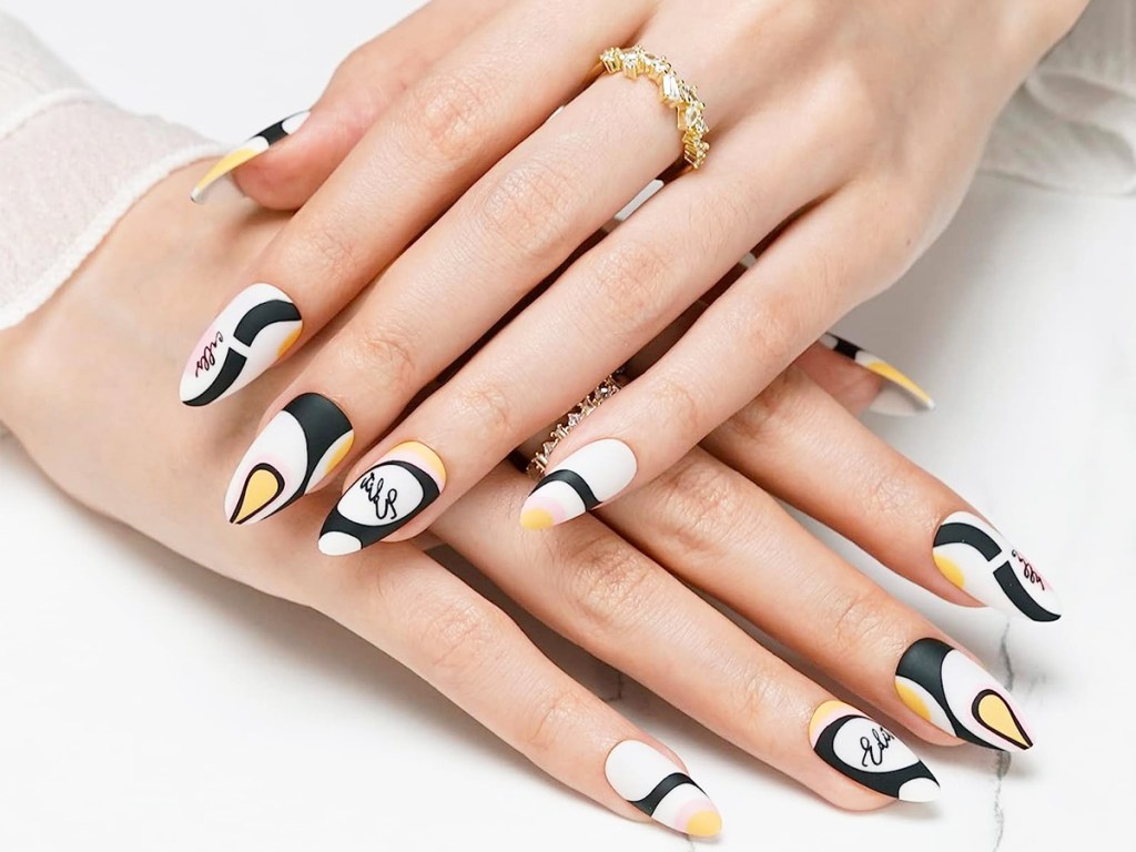 hands with abstract printed press on nails