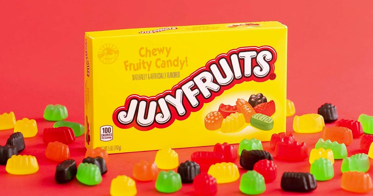 a box of Jujyfruits candies with loose candies scattered about