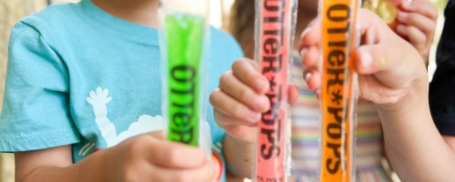 3 kids eating different colored otter pops