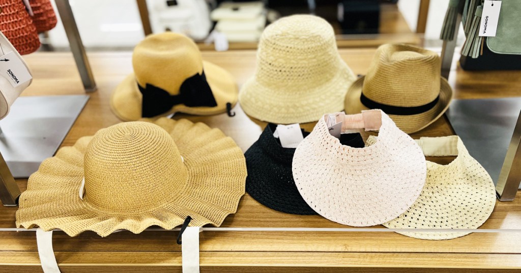 display table full of women's straw hats in store