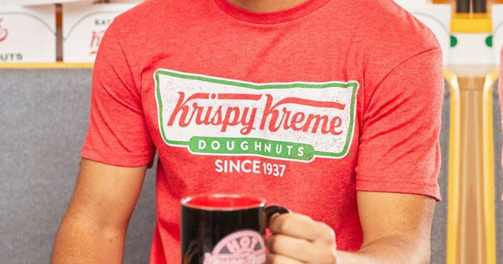man wearing a krispy kreme shirt and using a krispy kreme mug