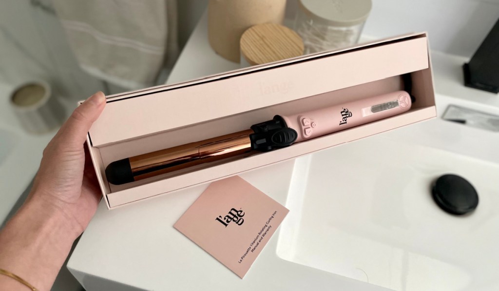 Hand holding Le Pirouette, the latest L'Ange curling iron.