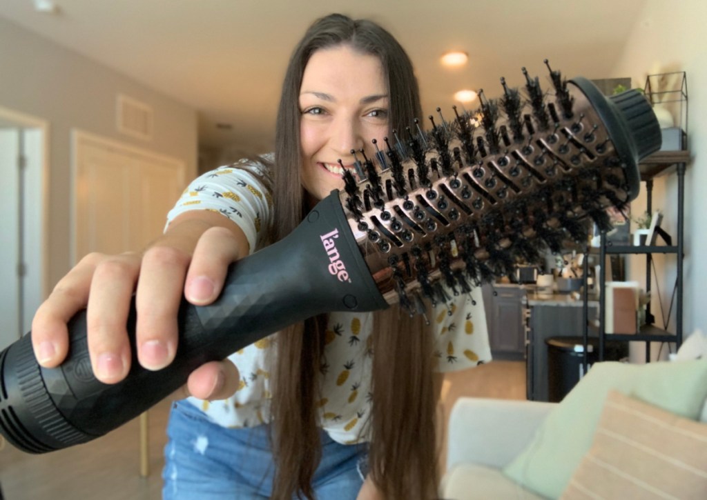 Woman holding a L'ange hair dryer brush called Le Volume